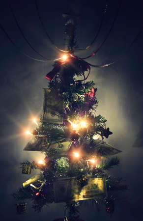 Dollar background christmas, pine tree branches, new-year fir tree is decorated with 100 dollars. hundred-dollar bills laid out on the branches of the Christmas treeの写真素材