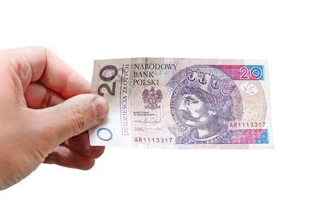 Close up on a 20 zloty banknote in a man's hand. Isolated object on white background.の写真素材