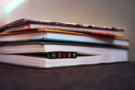 Love of books, reading. Stack of books in the colored cover lay on the table. Open book with curled leaves in the shape of a heart. Library, education. Empty space for Your text. inscription hobbyの写真素材