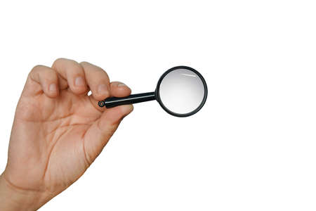 Magnifying glass in a hand isolated on a white background. Concept of searching, looking through magnifier, researching and scanning. Isolated male hand holding loupe. Using lens to look thoroughly.の写真素材
