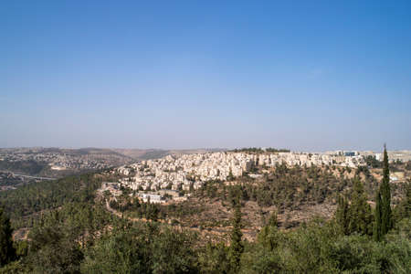 Panoramic aerial view on highway among the hills of Jerusalem, Israel. Modern houses of Jerusalem on a slope on the outskirts of the city among the trees.の写真素材