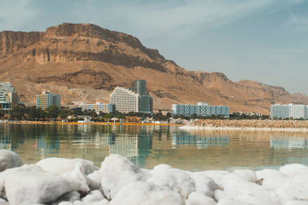 View of the coast and spa hotels at Dead Sea, Ein Bokek, Israel. Salt formations in the foreground. Travel Israel. large salt crystals. daytimeの写真素材