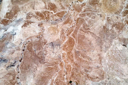 Aerial view of the Judean desert located on the West Bank of the Jordan river. Deserted shore of dead sea. The background of desert. Sandy stony canyon in the desert. A barren land. Midbar Yehudaの写真素材