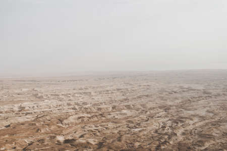 Aerial view of the Judean desert located on the West Bank of the Jordan river. Deserted shore of dead sea. The background of desert. Sandy stony canyon in the desert. A barren landの写真素材