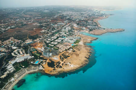 Cyprus beautiful coastline, Mediterranean sea of turquoise color. Houses on the Mediterranean coast. Tourist town with a Long beach. Summer vacation at sea. top view, aerial view. Cyprus, Ayia NAPA.の写真素材