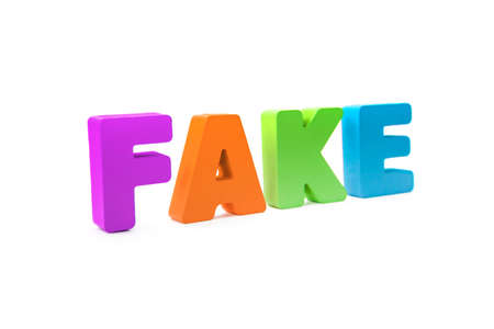 Many-colored isolated wooden word FAKE made with 3d text effect. Concept of false information, distortion of fact. Misinformation sign on white background. Mass media fake news. Falsehood about event.の写真素材