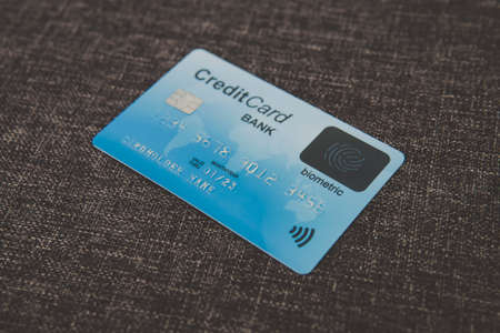 Close up of credit biometric card belonging to abstract cardholder lying on coarse fabric. E-shopping using advantages of fingerprint scanning. Simplicity and security of biometrics in banking. Chip.の写真素材