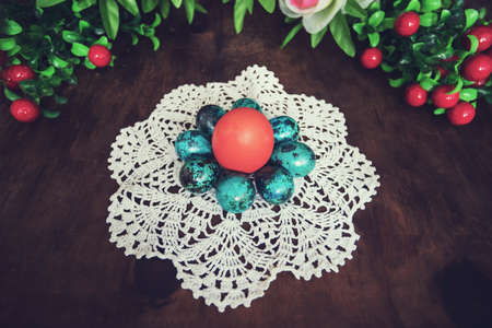 Easter picture. In a ray of light on a white linen napkin lies a group of red and blue chicken, quail eggs.の写真素材