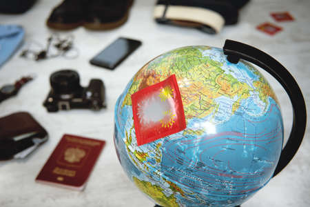 Collecting things the sex tourist on vacation. A tourist going on vacation for sexual services. Various things for overseas travel. Condoms on the globe.の写真素材