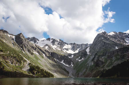 Mountain Lake in the spring. Landscape in the morning. Last snow on the hills. Reflection of the sky in water. Carpathians, Ukraine, Europeの写真素材