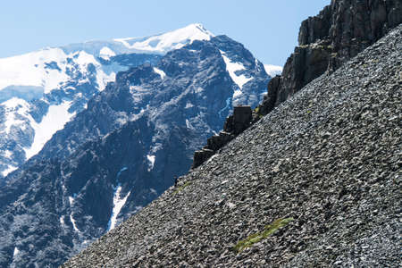 man climbing steep mountain. Good image for adventure, struggle and success story photo. Amateur mountaineering against the blue sky .の写真素材