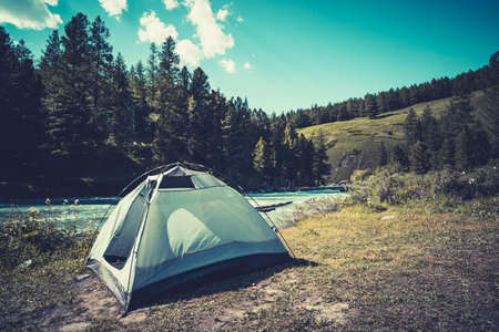 Camping tent in campground at national park. Tourists camped in the woods on the shore of the lake...