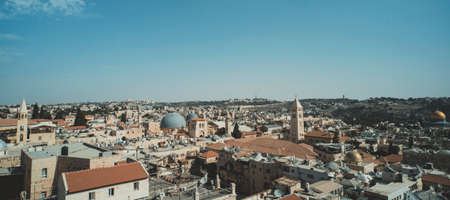 Roofs, buildings, Holy Sepulcher Church Dome and high minarets in old part of Jerusalem, Israel. Aerial view of ancient capital of Israel. Regular life of the jewish city on a sunny summer dayの写真素材