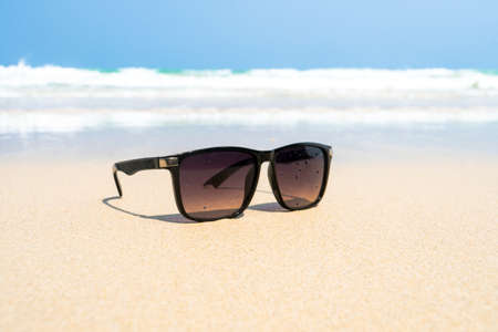 men's black Sunglasses on the beach. Beautiful sea view wallpaper, backgroundの写真素材