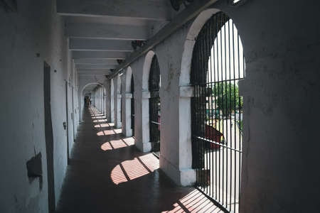 abandoned corridor in old prison. Long Corridor in Cellular Jail, Port Blair, Andaman Islands, India. Solitary confinement cells along the white wall of an old prisonの写真素材
