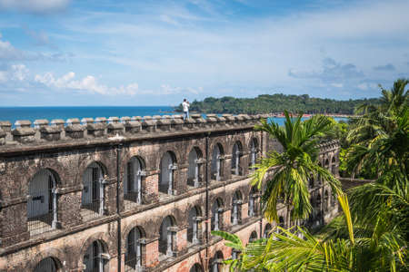 tourist stands on the roof of the prison in port Blair and takes a panoramic photo of Ross island. From the hill there is a beautiful view of the sea. Andaman islands.の写真素材