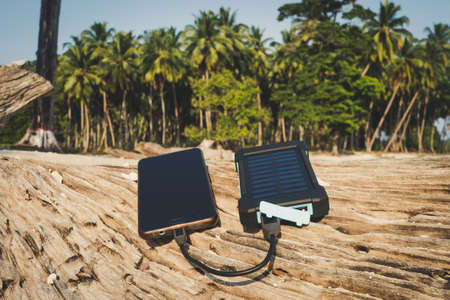 Smartphone close up on a sandy beach with copy space, the concept of restoring strength and energy....