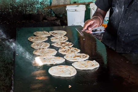 Indian chapatti on fire, Pushkar, India Close up. Fried tortillas on a hot baking sheet. Street food. Naan. Parathaの写真素材