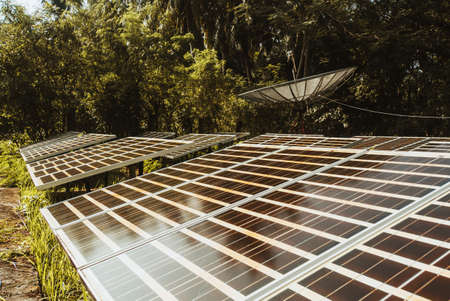 modern satellite dish and solar panels in the jungle forest. satellite dish, satellite aerial, satellite receiverの写真素材
