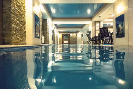 A small home pool into a rich house. Luxury villa. Modern indoor pool in SPA at hotel.の写真素材
