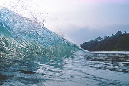 Wave Crest a wave peaks and crests against a blue skyの写真素材