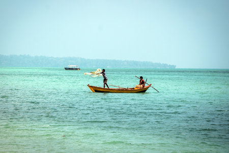 HAVELOCK ISLAND, ANDAMAN AND NICOBAR, INDIA 18 January 2018 : Local fishermen with boat in sea. the couple is engaged in fishing by means of a networkのeditorial素材