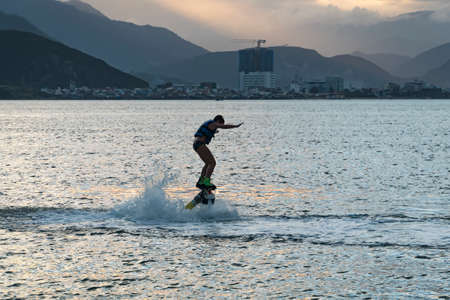 Flyboard. Air Farthest flight by hoverboard. boy flying on Board. Flyboard is aerial machine for personal watercraft, allows propulsion underwater. child having fun at sea.の写真素材