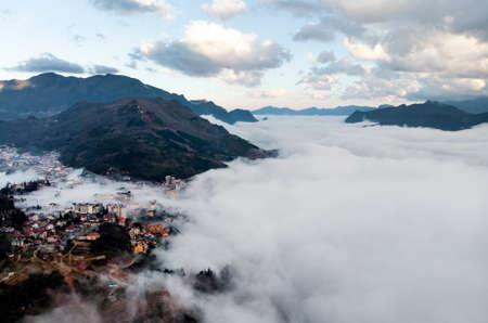 Bed of fog and clouds between the mountain valley in Sapa, Vietnam. Mountains among the clouds. Beautiful landscape with high mountains, blue sky and white clouds.の写真素材