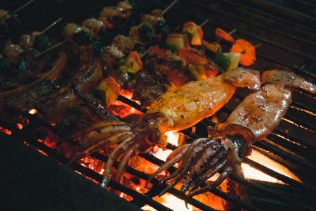 Squids, vegetables, mushrooms, frog, cooked on an open fire in the street. street Vietnamese food....