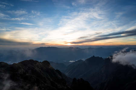 Sun-set moment, scenery of mountains in layers, dark violet purple silhouette panoramic view.の写真素材