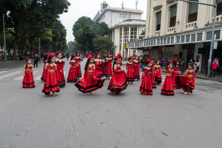 Young girls and Children dressed in traditional dress dance on the street smiling in Hanoi. Vietnam. 13 January 2019のeditorial素材