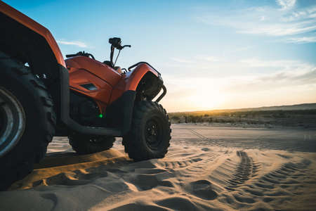 ATV Quad Bike in front of sunrise in the desert. ATV stands in the sand on a sand dune in the desert. MUI Ne. Vietnamの写真素材