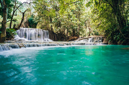 The waterfall and small cool pond with turquoise water. Concept of ecological tourism. Fantastically...