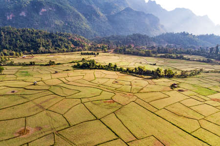 Aerial view of farm fields and rock formations in Vang Vieng, Laos. Vang Vieng is a popular destination for adventure tourism in a limestone karst landscape.の写真素材