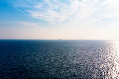 Ocean view in sunny summer day. Cargo boat on the horizon.の写真素材