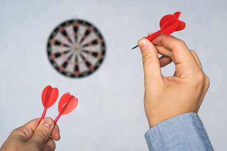 Businessman holding a dart aiming at the target - business targeting, aiming, focus concept. man in blue shirt playing Darts. hit the target. Success in business.の写真素材