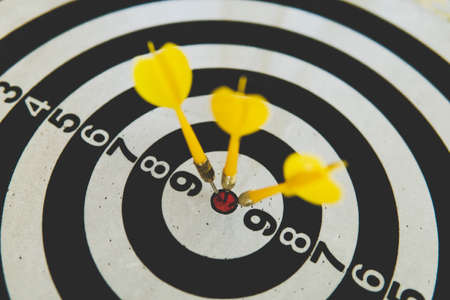 three yellow dart on board right direction hit target goal. Competition game to win focus on achievement with smart thinking planning accurate strategy. Outstanding perfect performanceの写真素材