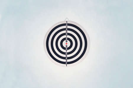 Dartboard on blue wall. Darts a series of related games in which players throw Darts at a round target hung on the wall.の写真素材