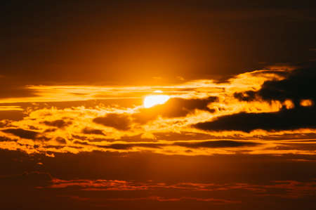 Gorgeous scenic of strong sunrise with silver lining and cloud on the orange skyの写真素材