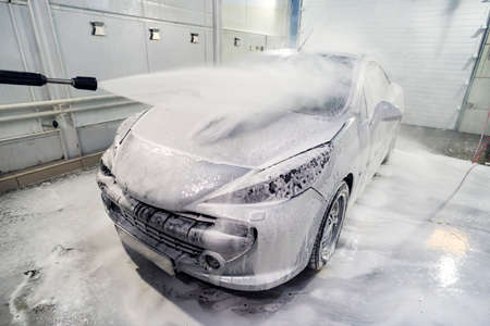 car is covered with foam to wash the car. Automatic car wash. Shampoo for cars. Cleaning process. self-service,の写真素材
