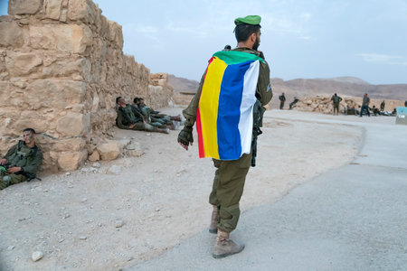 Masada, Israel. 23 October 2018: Soldier walking with a descending green, red, yellow, blue and whit...