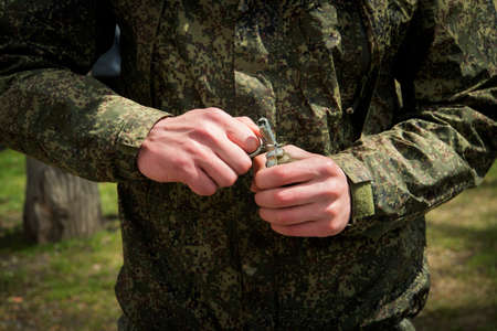 Military hand grenade throwing, pulling. Self-explosion. hands of the soldier pull the pin.の写真素材