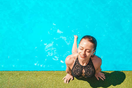 Portrait of trendy fit girl in swim wear with close eyes enjoying rest sunlight over blue water background, travel tourism journey trip tour concept. empty space for test and design.の写真素材