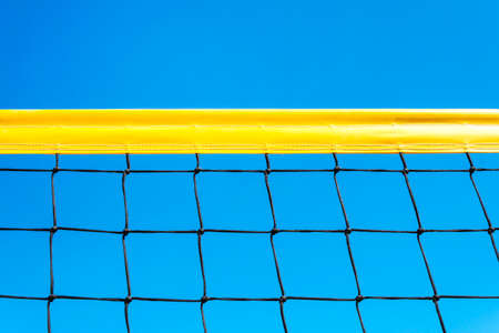 yellow colored summer games ball background - beach volleyball or tennis net against blue sky for sport events. copyspace. copy spaceの写真素材