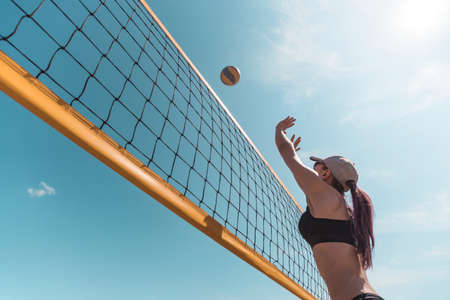young girl playing beach volleyball. Outdoor sports games.の写真素材