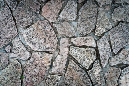 Close up of cold and wet stone path. Stone walk texture, background with cracked stone material. Abstract ancient dark granite walk. Exterior design natural materials. Ground shot from aboveの写真素材