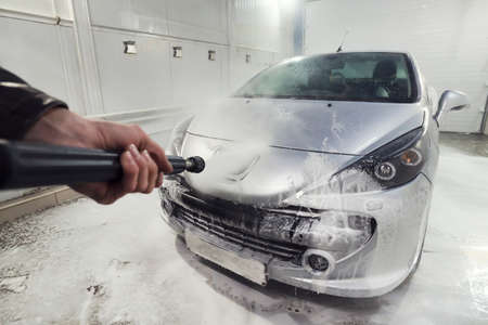 Cleaning sport Car Using High Pressure Water. Man washing his car under high pressure water in service. man worker washes car. self-serviceの写真素材