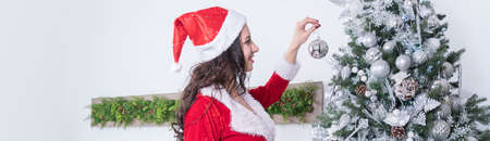 sexy women in the Santa costume holding Christmas ball for Christmas tree.の写真素材