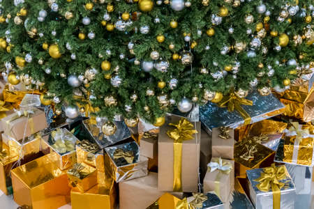 Gift boxes with Christmas tree at the background for surprise Children in New year or Xmas party festival. Christmas party event and Happy new year theme. Decorated property in worm home.の写真素材