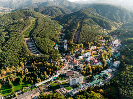Top view of the resort town Belokurikha. Bird's-eye view of the houses among the forests on the slopes of the mountains. Aerial view of a small town in the Altai territoryの写真素材
